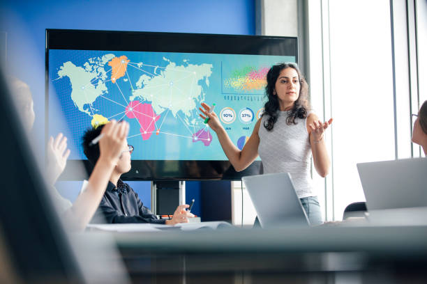 A businesswoman presents global travel routes at a meeting, highlighting strategies for starting a travel company in Dubai.