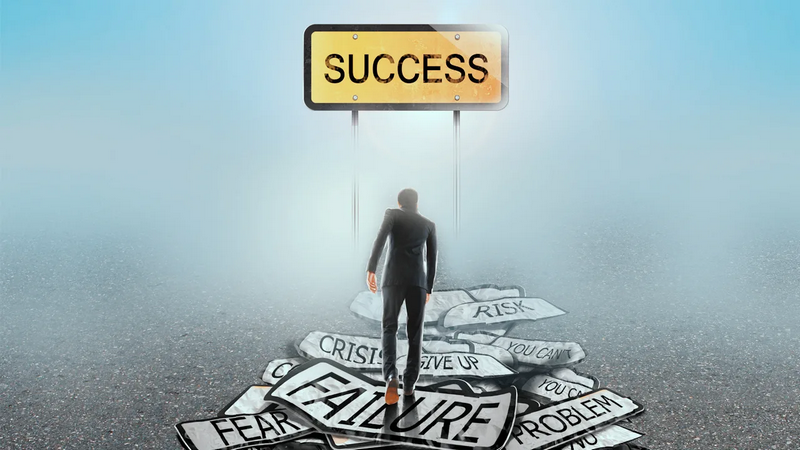 A person in a suit walks towards a sign that says SUCCESS while stepping on signs that say FAILURE and