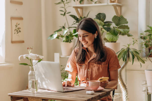 Freelancer working on a laptop in a cozy, plant-filled home office, illustrating freelance life in Dubai.